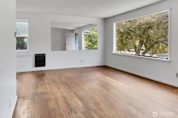 Main living room with hardwood floors and a big west facing window.