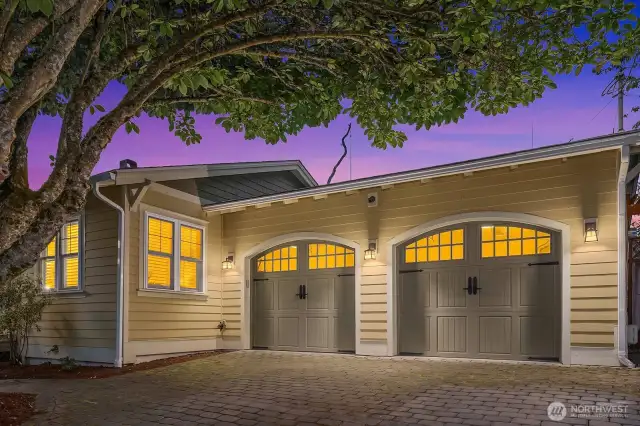 Two car garage with beautiful custom doors and brick paver driveway gives excellent curb appeal.