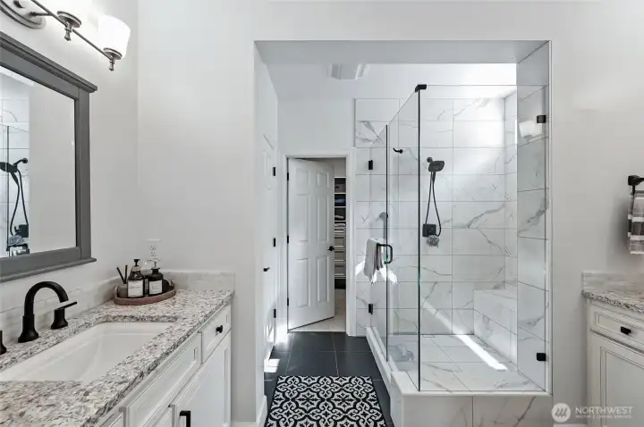 Separate vanities with white cabinetry, stunning counters and undermount sinks. The shower was reconfigured to make it larger with a bench seat.