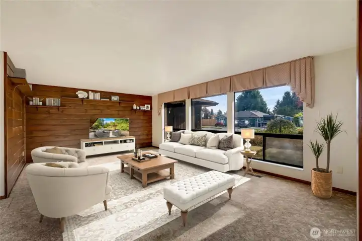 The spacious formal living room is bright and inviting, with sunlight streaming through large windows.  [This photo is virtually staged.]