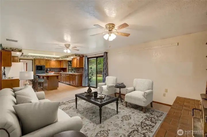 A sliding glass door and a kitchen skylight flood this space with natural light and provide direct access to the spacious back patio—making indoor-outdoor living effortless, whether entertaining guests or enjoying quiet evenings under the stars.  [This photo is virtually staged.]