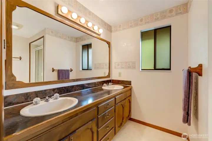 Primary bathroom with dual sinks and large, walk-in shower.