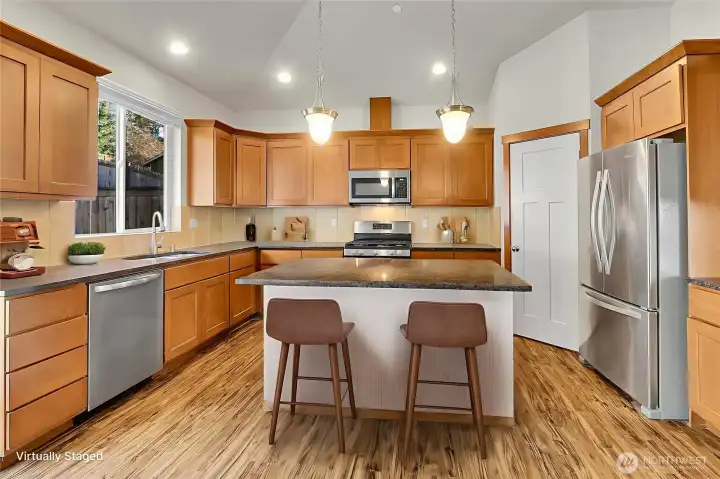 The generously sized kitchen is fully equipped with plenty of cabinets, a walk-in pantry, and modern stainless steel appliances, all of which are included with the home.