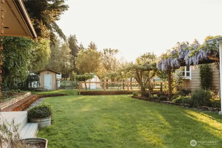 Come see the magical backyard for yourself! Tended to with love and planted with fruit trees, wisteria, roses, and more in an English garden style and already set up with veggie gardens for the harvest of your dreams. Come see the magical backyard for yourself! Tended to with love and planted with fruit trees, wisteria, roses, and more in an English garden style and already set up with veggie gardens for the harvest of your dreams.