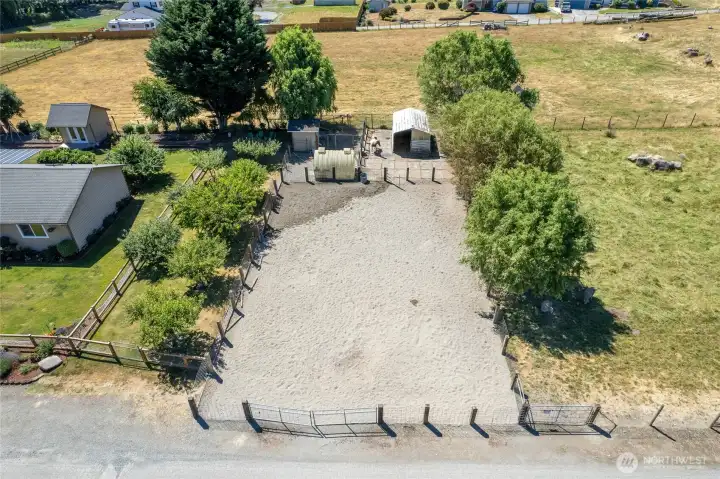 View of horse arena, outbuildings, orchard and field to the right.