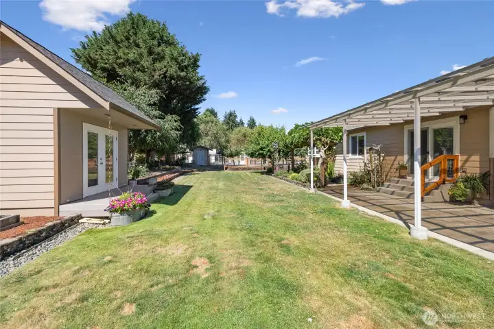Back yard off of the kitchen- great for entertaining.   An extruded aluminum patio cover blocks approximately 70% of UVA and UVB rays, creating a more comfortable outdoor living space. Creative Cottage seen to the left.