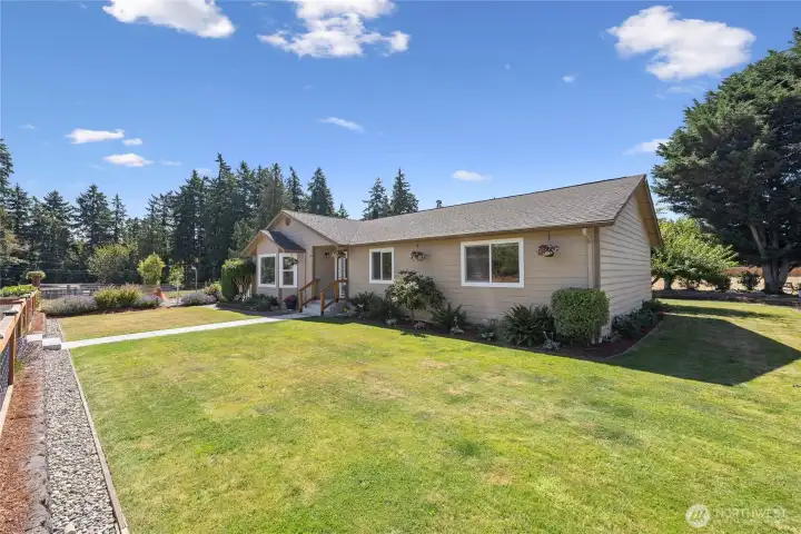 Large, fully fenced, yard with field drainage visible.