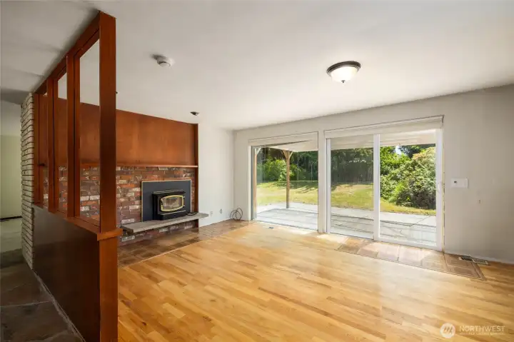 A view of the dining room from the entryway.  The floor-to-ceiling windows bring the outdoors in. Living room is beyond, to the left.