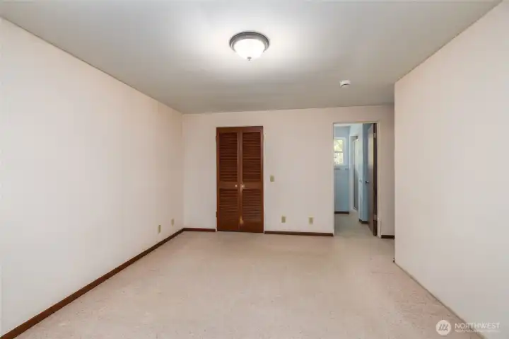 Primary bedroom, with bathroom visible in the back