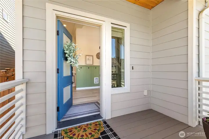 Covered front entry features durable composite decking, an improved front door lock, and a modern glass-panel door opening to reveal the main landing's custom board-and-batten accent wall. Covered front entry features durable composite decking, an improved front door lock, and a modern glass-panel door opening to reveal the main landing's custom board-and-batten accent wall.