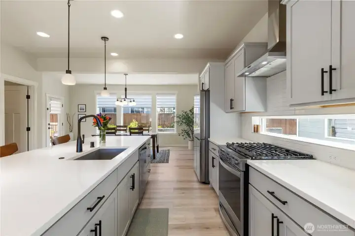 Gourmet kitchen details include a professional gas range, elegant tile backsplash, modern fixtures, under-mount sink, and a large center island perfect for entertaining. Gourmet kitchen details include a professional gas range, elegant tile backsplash, modern fixtures, under-mount sink, and a large center island perfect for entertaining.