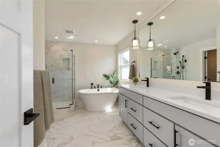 Spa-like primary bath features a long double vanity with slab quartz countertops, contemporary under-mount sinks, premium fixtures, and tile flooring. Spa-like primary bath features a long double vanity with slab quartz countertops, contemporary under-mount sinks, premium fixtures, and tile flooring.