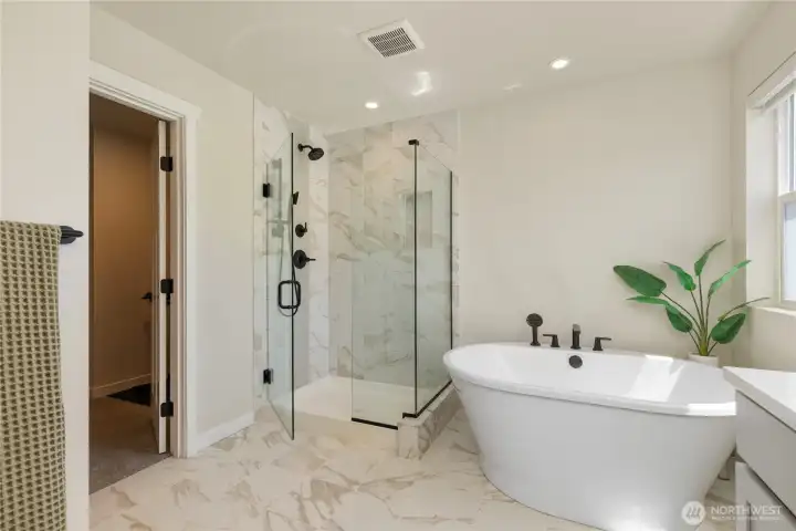 Primary bath detail highlights a luxurious free-standing soaking tub, a large walk-in glass tile shower, and contemporary design elements. Primary bath detail highlights a luxurious free-standing soaking tub, a large walk-in glass tile shower, and contemporary design elements.