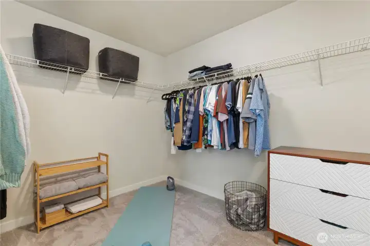 Expansive primary walk-in closet features 2025 custom closet storage with tailored built-in shelving, clothing rods, and organized compartments. Expansive primary walk-in closet features 2025 custom closet storage with tailored built-in shelving, clothing rods, and organized compartments.