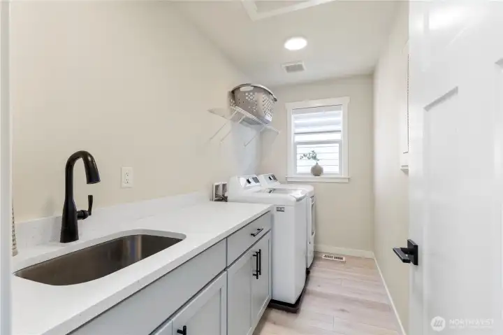 Functional utility space features built-in laundry cabinetry, a deep utility sink, laminate countertops, and durable low-maintenance flooring. Functional utility space features built-in laundry cabinetry, a deep utility sink, laminate countertops, and durable low-maintenance flooring.
