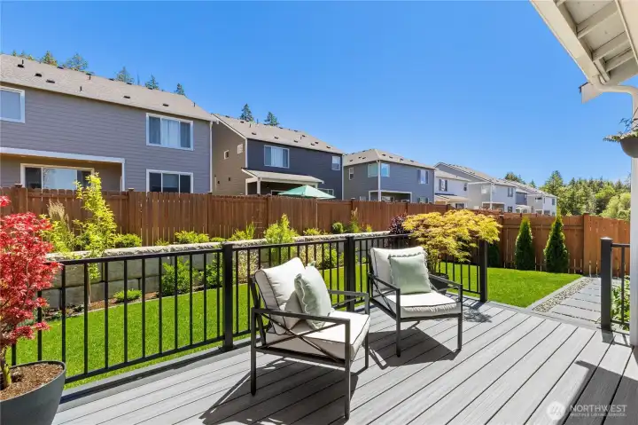 Beautifully manicured, fully fenced backyard showcases a plush green lawn, custom 2024 landscaping, and a low-maintenance gravel seating area. Beautifully manicured, fully fenced backyard showcases a plush green lawn, custom 2024 landscaping, and a low-maintenance gravel seating area.