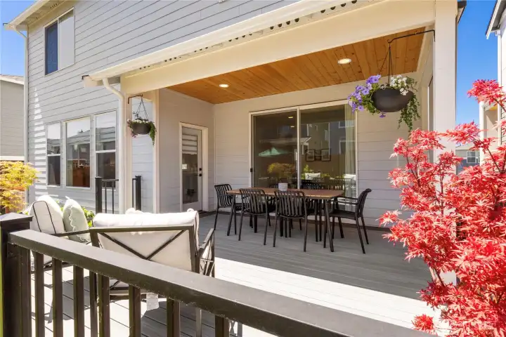 Rear view of the modern home highlighting the architectural upper custom composite deck, covered lower patio, and pristine siding Rear view of the modern home highlighting the architectural upper custom composite deck, covered lower patio, and pristine siding