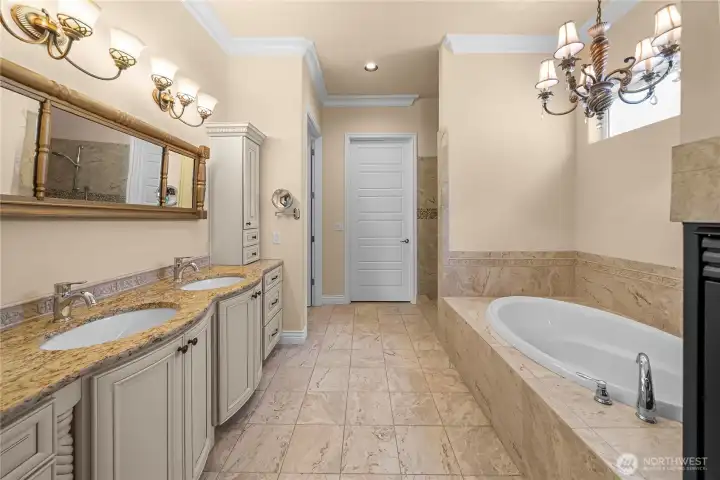 A spa-like massive master bathroom with huge soaking tub, glass fire place, dual sinks creates the perfect place to relax & unwind