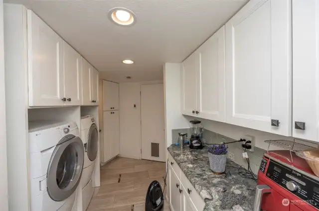 Laundry with lots of cabinets, washer, dryer, granite counter, wine refrigerator  and sink which you can't see