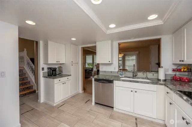 Large kitchen with endless cabinetry that continues into the laundry area with granite counter tops, recessed lighting and cove ceiling with crown molding