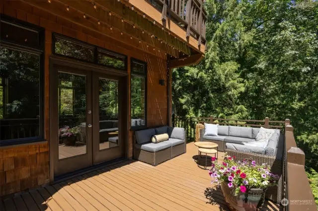 The double doors lead from the living room onto the spacious deck where you feel like you are connected with the surrounding forest
