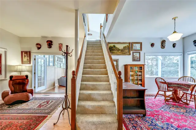 Standing at the fireplace wall you view the sunporch left and dining room with views across the meadow to Port Townsend Bay.