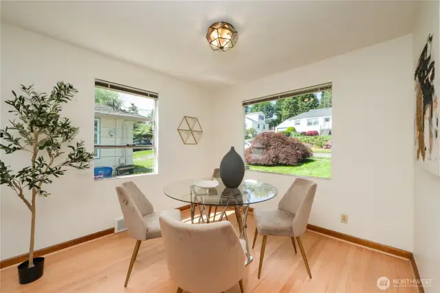 Sunny dining room has corner windows and fresh hardwoods.