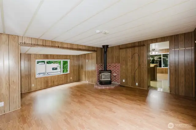 This view of the living room shows another large picture window and the entry into the front kitchen-dining area.