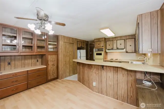 This view from the dining area shows the pantry with sliding doors at center, and a closet to the right side of the fridge.