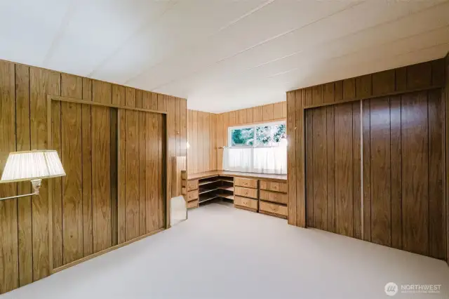 Primary bedroom with two double closets and built-in dresser storage under the corner window.