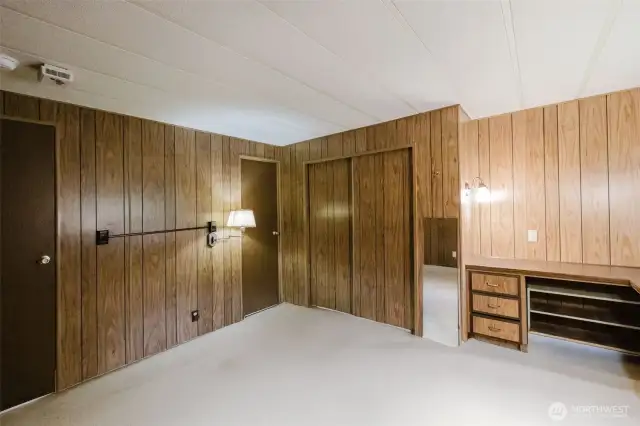 Primary bedroom with door to hallway at the left, and the door to the bathroom in the center.