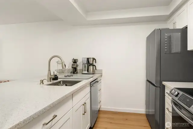 Quartz counters, stainless appliances accentuate this light & bright kitchen.