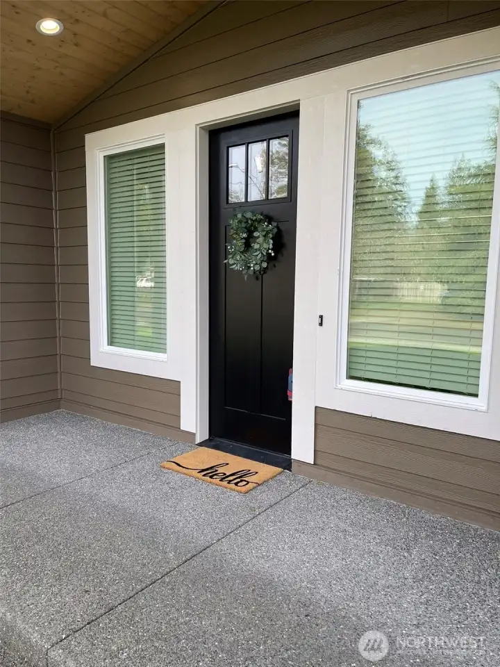 Large front entrance with surrounding huge windows and door.