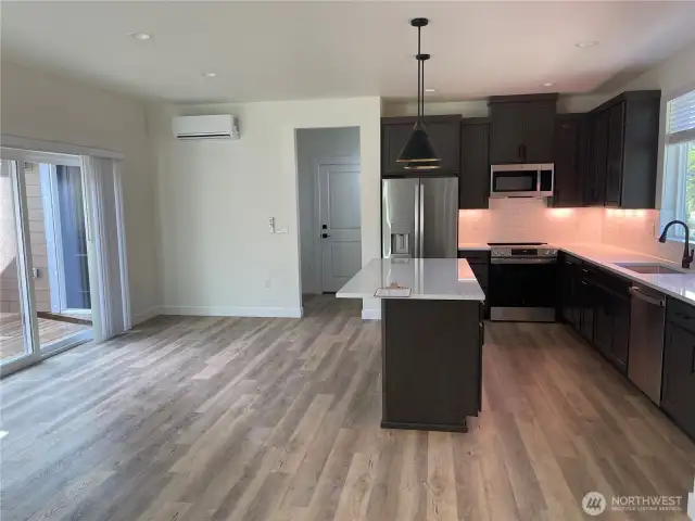 Kitchen eating area with slider leading to back deck. Door in background leads to garage and there is a walk-in pantry just to the left of the garage door.