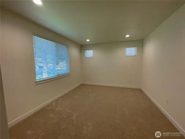 Primary bedroom looks out to front yard and has two transom windows for even more brightness.