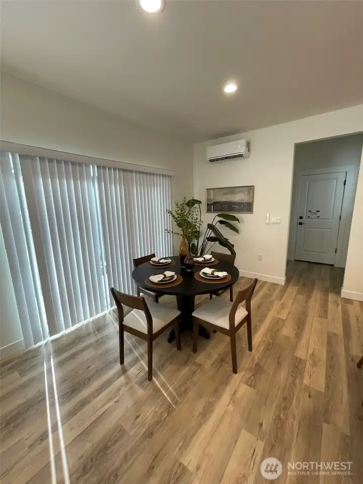 Eating area with slider leading to back deck. Door in background leads to garage and there is a walk-in pantry just to the left of the garage door.