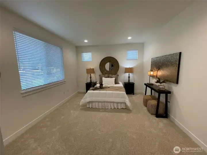 Primary bedroom has large window and additional transom windows
