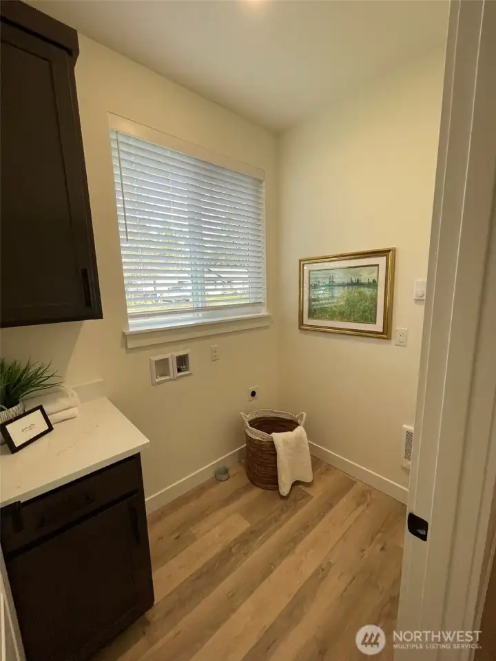 Utility room has some counter space and cabinet.