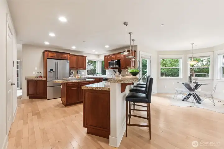 Chefs kitchen with stainless appliances, gas stove and eating bar.