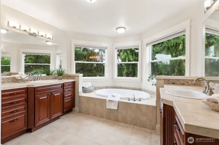 Primary bath with soaking tub and separate vanities.