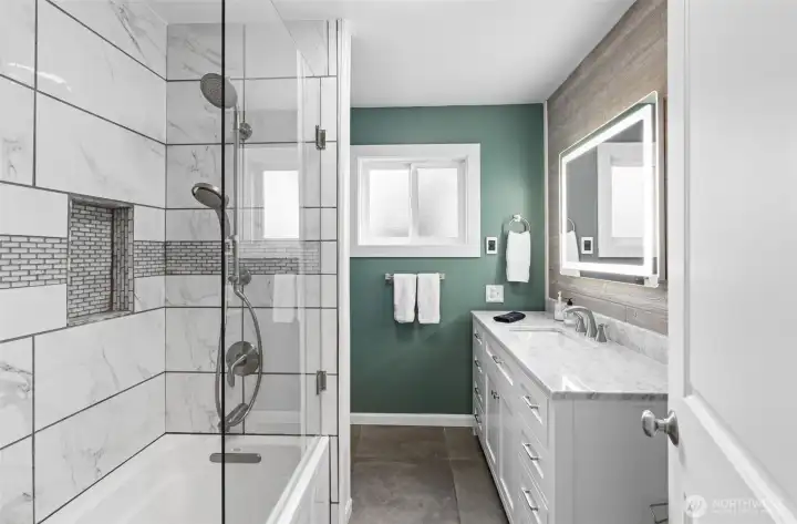 Main floor full bathroom with radiant floors, tiled bath and hard wired mirror.