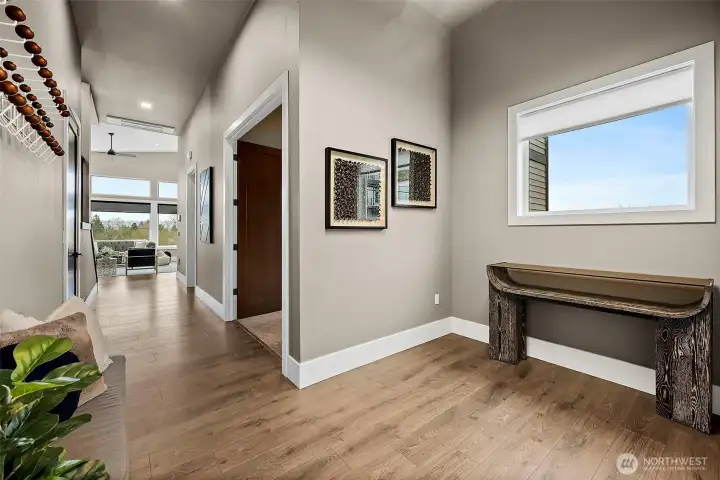 Welcoming entry foyer in this River Rock home in Auburn featuring wide plank flooring, modern finishes, and a bright hallway that opens toward the main living spaces. The clean design creates an inviting first impression as you enter the home.