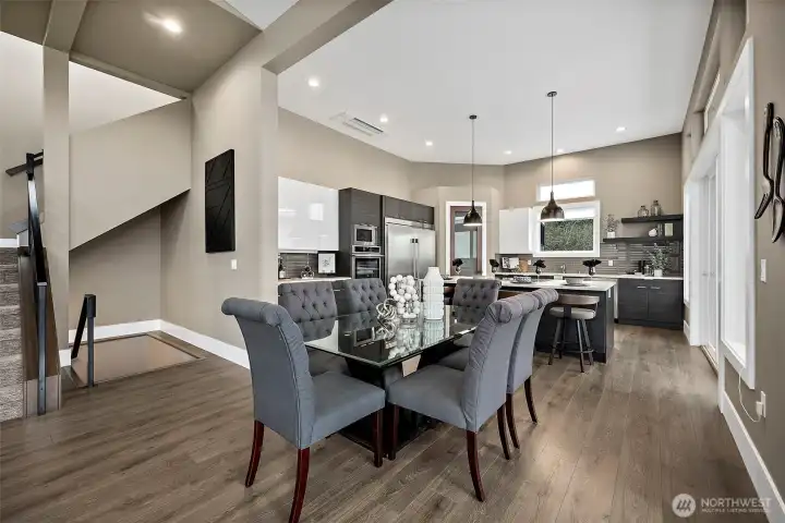 Dining area in this River Rock home features an open concept layout with large windows, modern lighting, and seamless flow into the kitchen and living space. The bright setting and spacious design create an inviting area for everyday meals and entertaining.