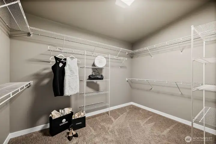 Spacious walk in closet with built in shelving and ample storage for clothing, shoes, and accessories. The organized layout adds convenience and functionality to this Auburn River Rock home.