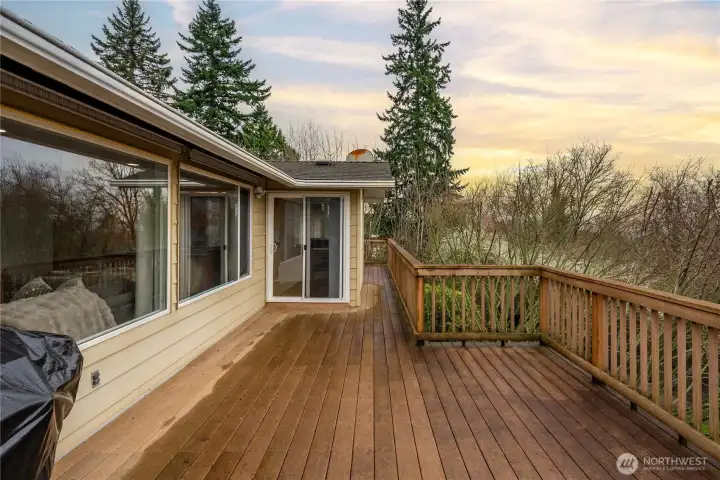 The main floor deck overlooking the backyard and the sunsets runs the length of the house