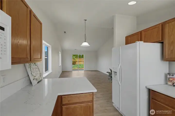 Kitchen w/ eating bar open to dining/living areas