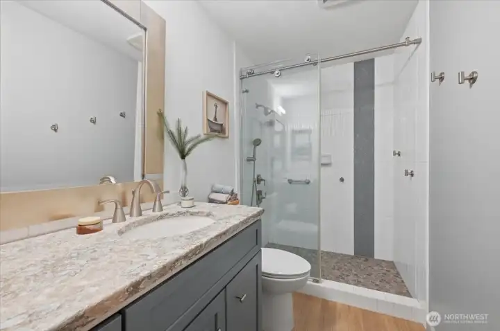 Main bathroom is designed with attention to details.  While enjoying low maintenance finishes and neutral waterside colors, the room also offers a dual length vanity for storage and working space because it is the in condo personal laundry space with stackable washer and dryer. ( on right - not pictured)