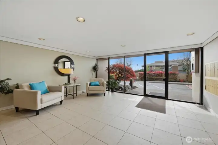 Main entrance facing west.  Common area used for meetings, gatherings and other social events.  Post boxes located on right wall and there is a package drop table not pictured  in back.