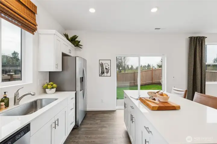 Quartz countertops and soft close doors on your cabinets in a beautiful kitchen space. Actual home is under construction and finishes, colors, and materials may vary. See site agent for details.