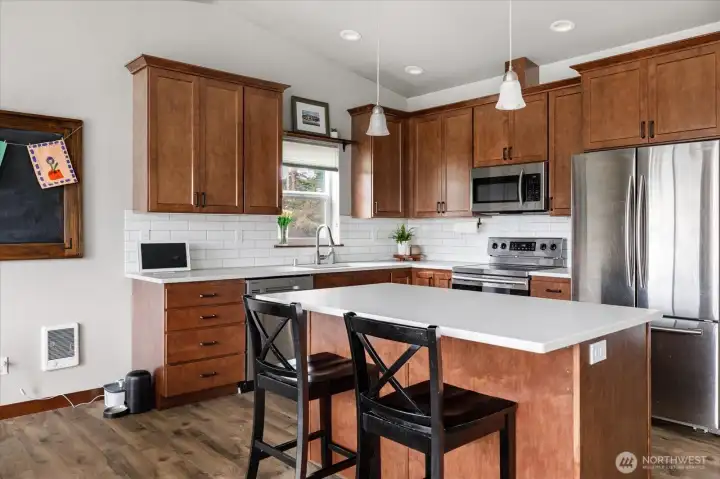 Light filled kitchen with granite counter tops, maple cabinets, & stainless steel appliances.